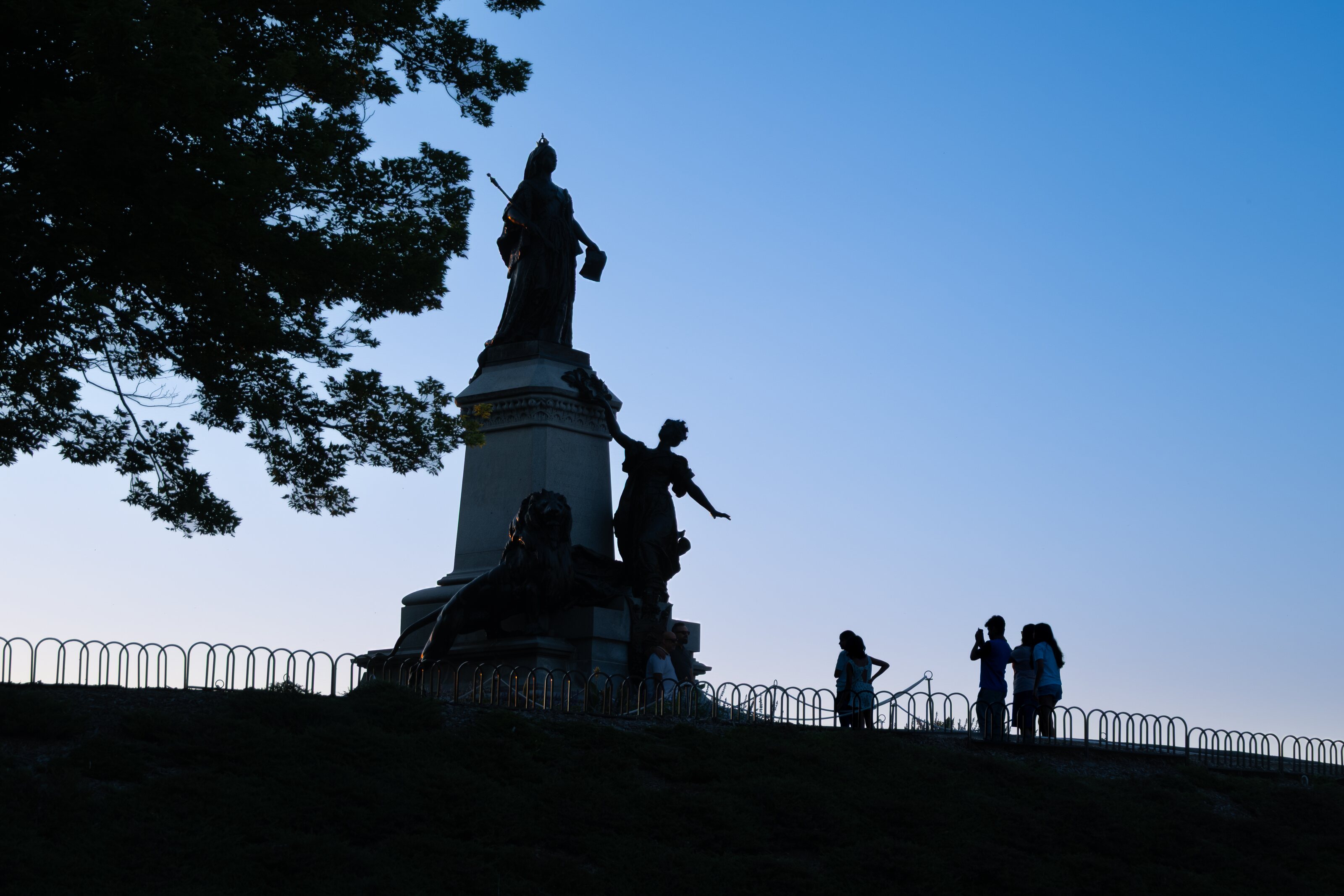 A monument silhouetted against a clear blue sky