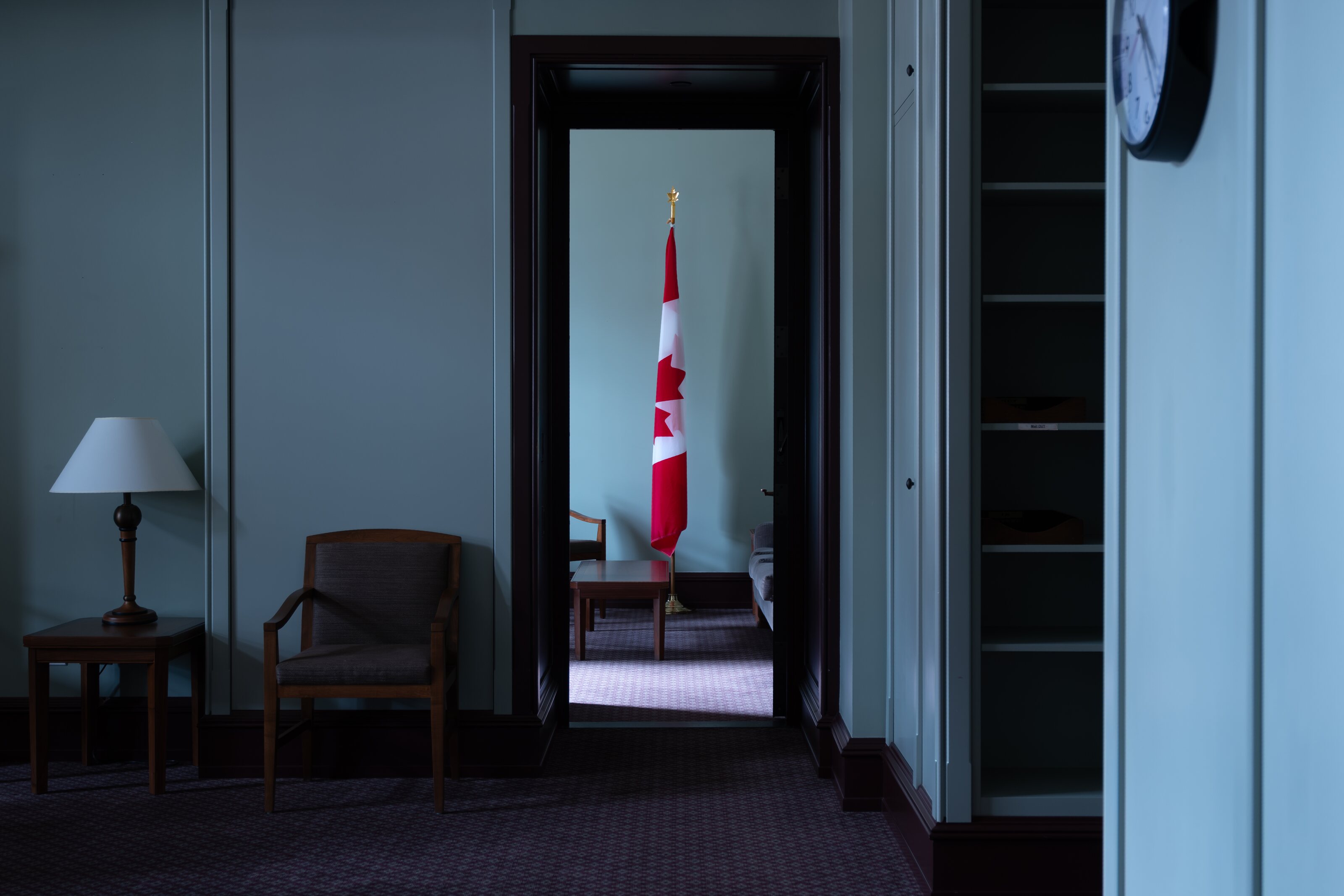 A Canadian flag seen through an open doorway