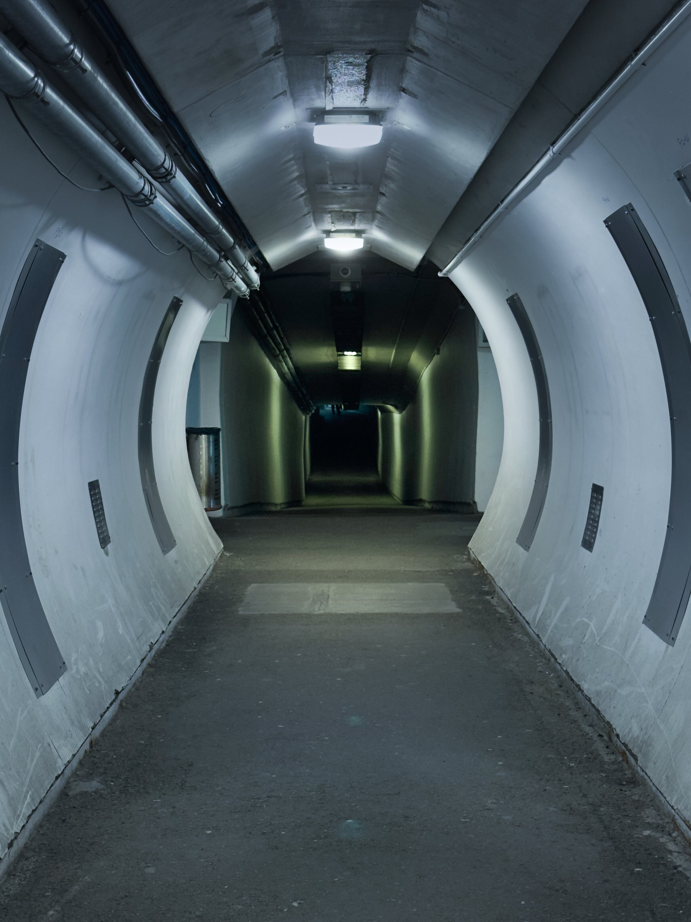 An empty curved corridor under fluorescent light